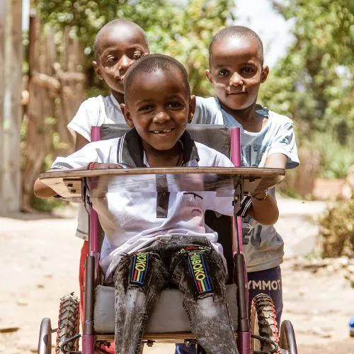 Foto van drie kinderen geholpen door MOTO project Tanzania